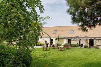 Un couple en tenue de mariage s'embrasse dans un jardin, avec des arbres en arrière-plan.