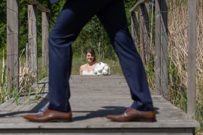 Un couple en tenue de mariage s'embrasse dans un jardin, avec des arbres en arrière-plan.