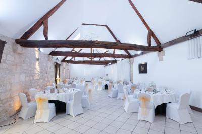 Un couple en tenue de mariage s'embrasse dans un jardin, avec des arbres en arrière-plan.