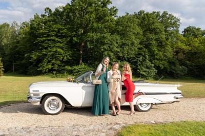 Un couple en tenue de mariage s'embrasse dans un jardin, avec des arbres en arrière-plan.