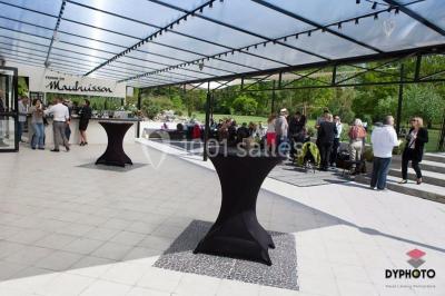 Un couple en tenue de mariage s'embrasse dans un jardin, avec des arbres en arrière-plan.