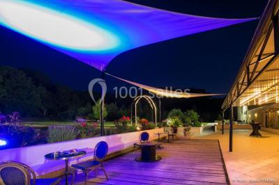 Un couple en tenue de mariage s'embrasse dans un jardin, avec des arbres en arrière-plan.