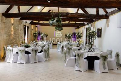 Un couple en tenue de mariage s'embrasse dans un jardin, avec des arbres en arrière-plan.