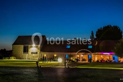 Un couple en tenue de mariage s'embrasse dans un jardin, avec des arbres en arrière-plan.