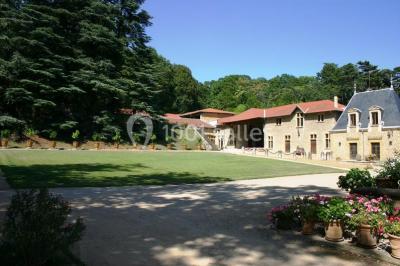 Lit avec baldaquin blanc, table de chevet en bois avec lampe en cristal, bougie et livres posés dessus.