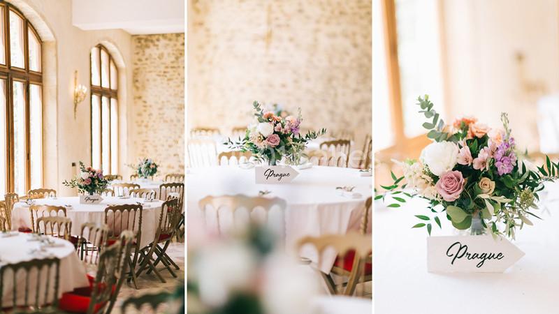 Tables de réception décorées avec des bouquets de fleurs et des marque-places indiquant ’Prague’.
