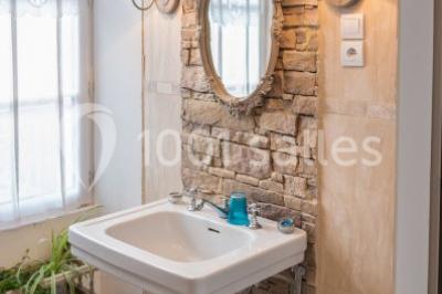 Disposition de chaises blanches en extérieur autour d'une allée menant à une petite scène sous une tente blanche.