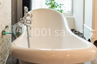 Disposition de chaises blanches en extérieur autour d'une allée menant à une petite scène sous une tente blanche.