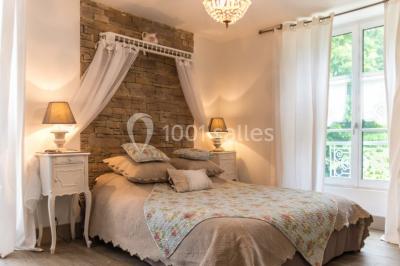 Disposition de chaises blanches en extérieur autour d'une allée menant à une petite scène sous une tente blanche.