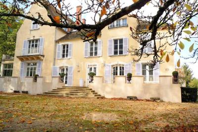 Disposition de chaises blanches en extérieur autour d'une allée menant à une petite scène sous une tente blanche.