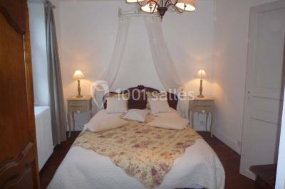 Disposition de chaises blanches en extérieur autour d'une allée menant à une petite scène sous une tente blanche.