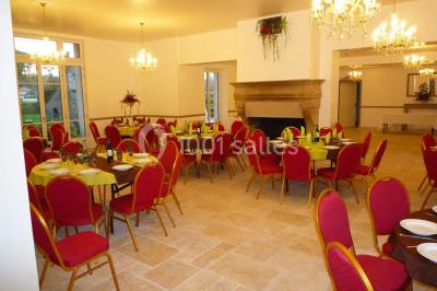 Disposition de chaises blanches en extérieur autour d'une allée menant à une petite scène sous une tente blanche.