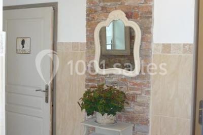 Disposition de chaises blanches en extérieur autour d'une allée menant à une petite scène sous une tente blanche.