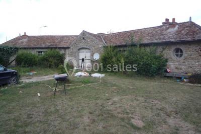 Mobilier de jardin en rotin avec coussins, disposé dans une véranda lumineuse avec des plantes en pot.