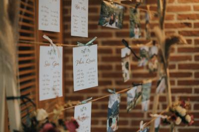 Maison en bois éclairée la nuit, entourée d'arbres illuminés, sous un ciel nuageux avec la lune visible.