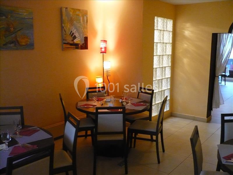 Salle de restaurant avec tables dressées, chaises modernes, éclairage tamisé et décorations murales colorées.