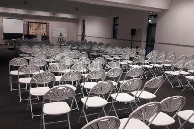 Table décorée avec un vase, des pétales rouges et des plantes en pot dans une salle lumineuse.