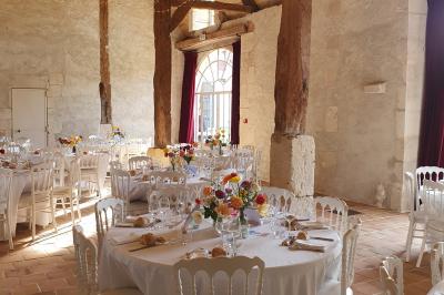 Serre illuminée au crépuscule, entourée de murs en pierre et d'arbres, avec une tour en arrière-plan.