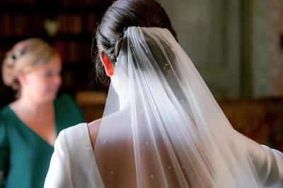 Bâtisse en pierre avec toit en tuiles, entourée de végétation et d'un chemin sous un ciel bleu clair.
