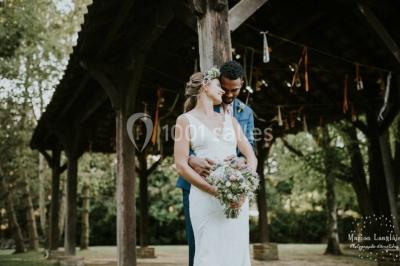 Un vélo ancien posé près de caisses en bois et d'objets décoratifs dans un jardin verdoyant.