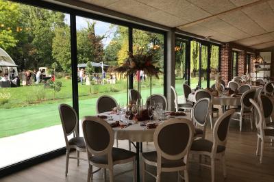 Un vélo ancien posé près de caisses en bois et d'objets décoratifs dans un jardin verdoyant.