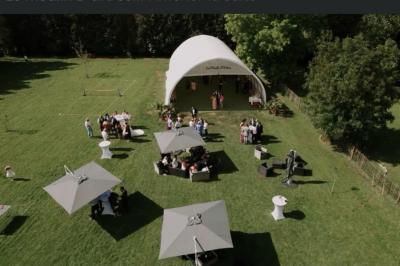 Un vélo ancien posé près de caisses en bois et d'objets décoratifs dans un jardin verdoyant.