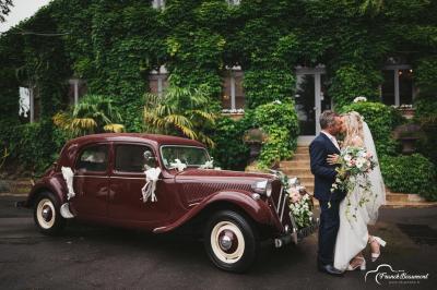 Un vélo ancien posé près de caisses en bois et d'objets décoratifs dans un jardin verdoyant.