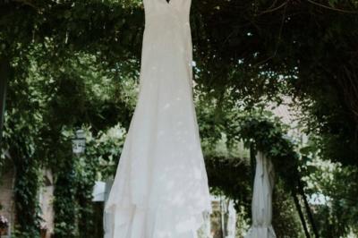 Un vélo ancien posé près de caisses en bois et d'objets décoratifs dans un jardin verdoyant.