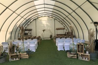 Un vélo ancien posé près de caisses en bois et d'objets décoratifs dans un jardin verdoyant.