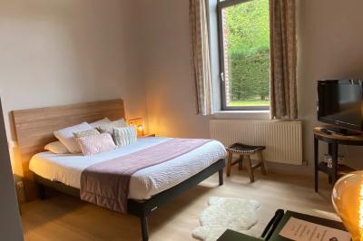 Un vélo ancien posé près de caisses en bois et d'objets décoratifs dans un jardin verdoyant.