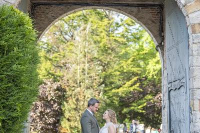 Un vélo ancien posé près de caisses en bois et d'objets décoratifs dans un jardin verdoyant.
