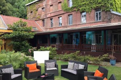 Un vélo ancien posé près de caisses en bois et d'objets décoratifs dans un jardin verdoyant.