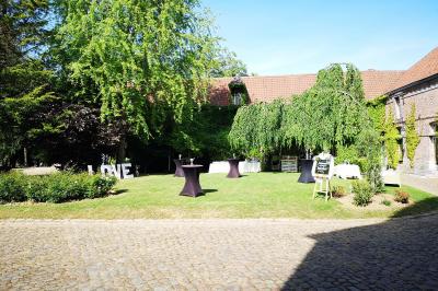 Un vélo ancien posé près de caisses en bois et d'objets décoratifs dans un jardin verdoyant.
