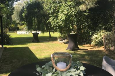 Un vélo ancien posé près de caisses en bois et d'objets décoratifs dans un jardin verdoyant.