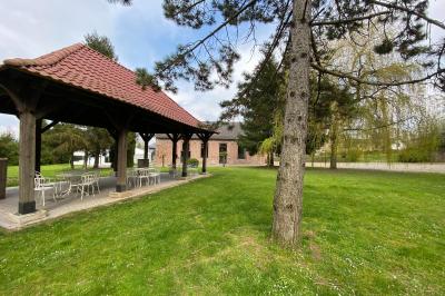 Un vélo ancien posé près de caisses en bois et d'objets décoratifs dans un jardin verdoyant.