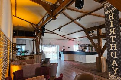 Table de buffet décorée de pampas, éclairée par des lumières violettes, avec plats et condiments disposés.