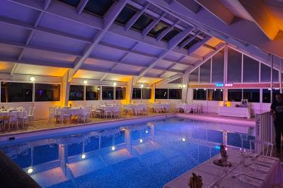 Table de buffet décorée de pampas, éclairée par des lumières violettes, avec plats et condiments disposés.