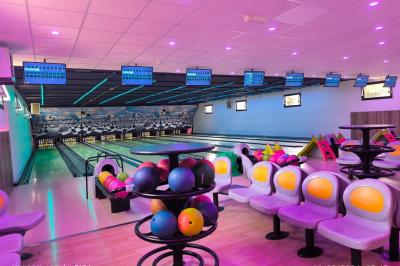Table de buffet décorée de pampas, éclairée par des lumières violettes, avec plats et condiments disposés.
