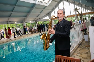 Table de buffet décorée de pampas, éclairée par des lumières violettes, avec plats et condiments disposés.