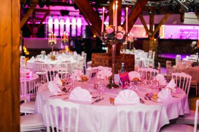 Table de buffet décorée de pampas, éclairée par des lumières violettes, avec plats et condiments disposés.
