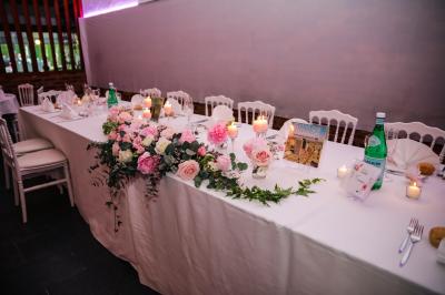 Table de buffet décorée de pampas, éclairée par des lumières violettes, avec plats et condiments disposés.