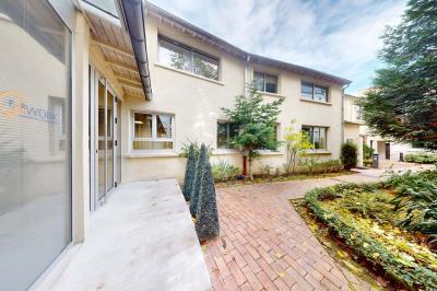 Salle de réunion avec une longue table rectangulaire, chaises noires, projecteur et murs blancs et rouges.