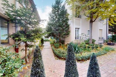 Salle de réunion avec une longue table rectangulaire, chaises noires, projecteur et murs blancs et rouges.