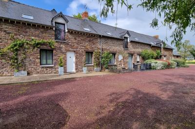 Un cheval de trait tire une calèche avec un conducteur et un passager, sur un chemin en milieu rural.