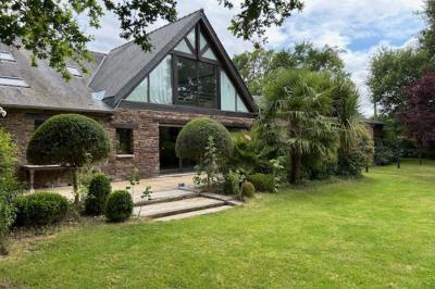 Un cheval de trait tire une calèche avec un conducteur et un passager, sur un chemin en milieu rural.