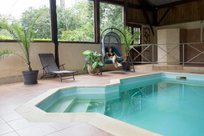 Un cheval de trait tire une calèche avec un conducteur et un passager, sur un chemin en milieu rural.