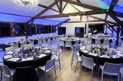 Un cheval de trait tire une calèche avec un conducteur et un passager, sur un chemin en milieu rural.