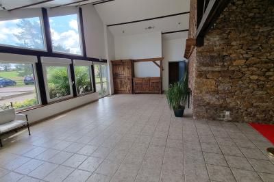 Un cheval de trait tire une calèche avec un conducteur et un passager, sur un chemin en milieu rural.