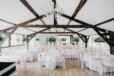 Un cheval de trait tire une calèche avec un conducteur et un passager, sur un chemin en milieu rural.