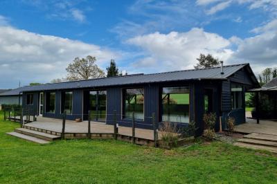 Un cheval de trait tire une calèche avec un conducteur et un passager, sur un chemin en milieu rural.